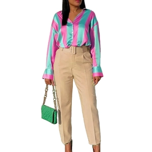 Detail of high waist khaki trousers with a wide belt and vertical stripe satin shirt