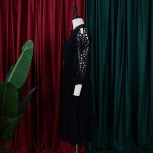 Detailed view of elegant lace hollow-out design on sleeves of black midi dress