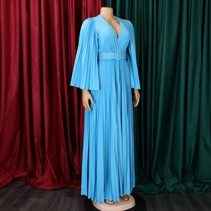 Détail de robe longue plissée bleu clair avec décolleté en V, manches cloche et ceinture