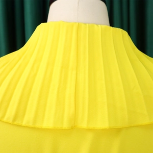 Vue macro détaillée des volants plissés jaunes et de la texture soyeuse du tissu au décolleté