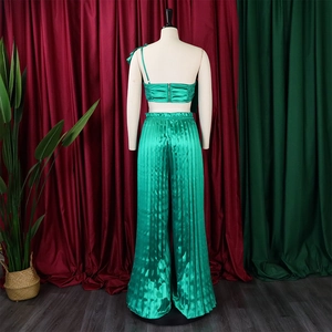 Detail of emerald green satin set with one-shoulder pleated top and wide-leg trousers