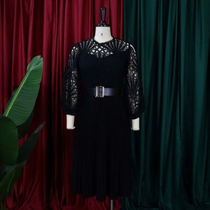 Detail of black lace hollow-out stitching and pleated hem dress with silver buckle belt