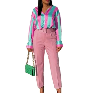 Close-up of pink high-waisted dress pants featuring a matching belt and tailored fit