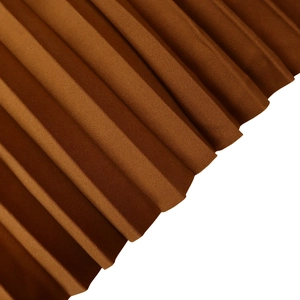 Makro-Detail des plissierten Stoffes in tiefem Karamell mit feiner Textur und Faltung