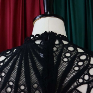 Close-up detail of black embroidered lace dress with hollow out design and invisible zipper