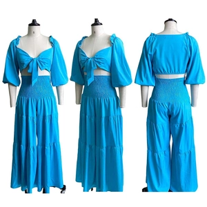Detail of bright blue two-piece set featuring lantern sleeves and smocked elastic waist