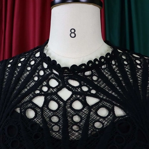 Detail of black hollow lace embroidery and round neckline on a stylish women dress