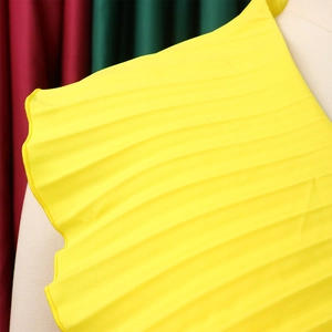 Vue détaillée du tissu plissé soleil jaune vif sur une robe longue d'été élégante