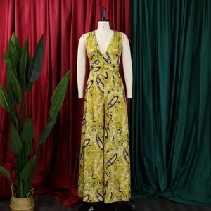 Detail of yellow paisley print wide-leg jumpsuit with deep V-neck and halter design