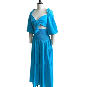 Detail of bright blue two-piece set with tie-front crop top and tiered maxi skirt