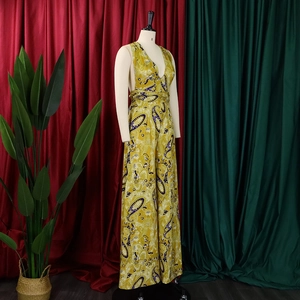 Detailed view of yellow paisley halter neck jumpsuit with deep V-neck and wide legs