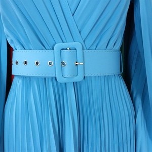 Détail de la robe plissée bleu ciel avec une ceinture large et œillets métalliques