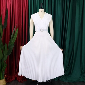 Détail d'une robe longue plissée blanche avec décolleté en V et volants aux épaules