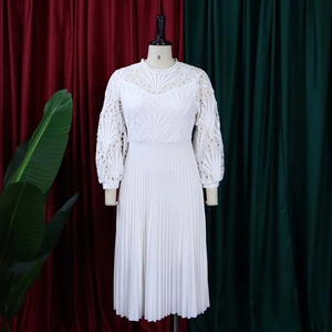Detail of white lace hollow-out embroidery and pleated skirt texture on a dress