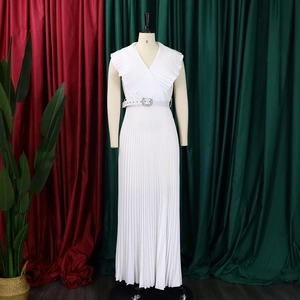 Gros plan sur une robe longue plissée blanche avec ceinture fine et boucle en strass