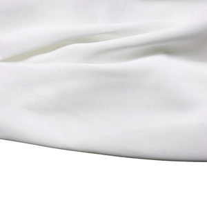 Macro detail of the high-quality white textile fabric showing fine woven texture and drape