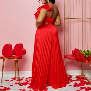 Detail of red off-shoulder ruffle top and pleated wide-leg pants in satin fabric