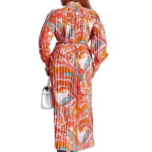 Rear view of long sleeve pleated maxi dress with orange and teal marble print pattern