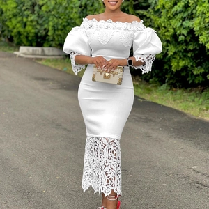Detail of white lace patchwork on a cold-shoulder dress with elegant puff sleeves