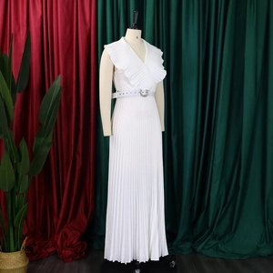 Détail d'une robe longue plissée blanche sans manches avec col en V à volants et ceinture