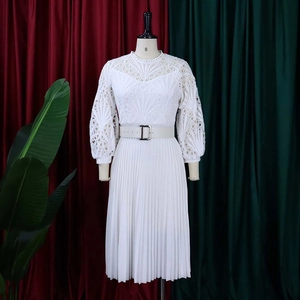 Detail of white lace hollow-out bodice and elegant pleated skirt on long sleeve dress