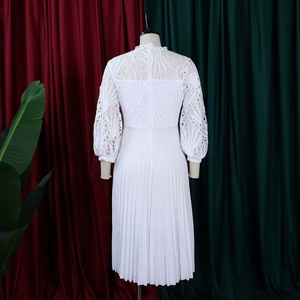 Detail of white lace hollow-out top and pleated skirt hem on this elegant maxi dress