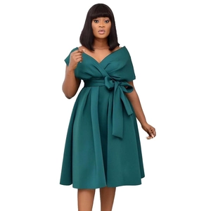 Detail of dark green V-neck dress featuring elegant waist tie and pleated A-line skirt
