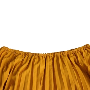 Detailed macro view of yellow pleated fabric texture and elastic smocked waist design