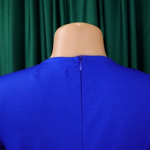 Close-up detail of invisible back zipper and textured fabric on blue mesh dress