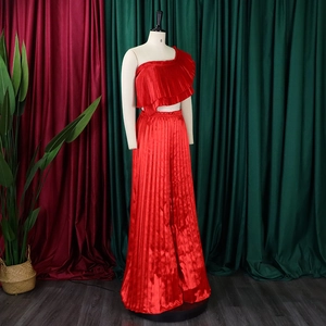 Detail of red one-shoulder ruffle top and high-waisted pleated wide-leg trousers set
