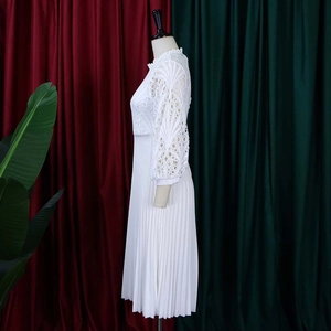 Detail of white lace hollow-out bodice and pleated skirt on a stylish midi dress