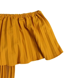 Macro detail of elastic off-shoulder neckline with yellow pleated fabric textures