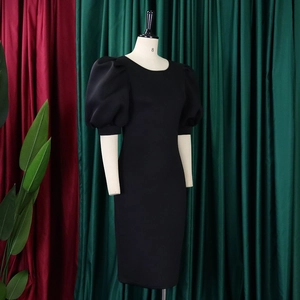 Detail of elegant black puff sleeve dress with crew neck and slim fit on a mannequin