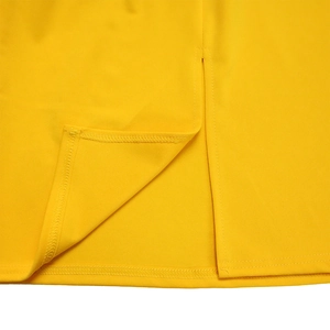 Detailed close-up of yellow dress hem featuring split design and precision stitching