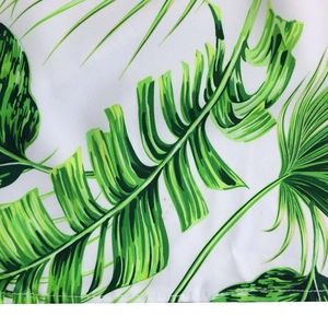 Vue détaillée de l'imprimé palmier tropical et des coutures sur un tissu blanc