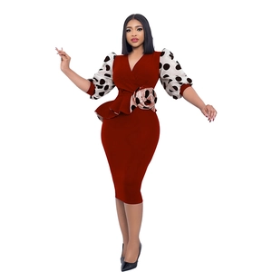 Detail of burgundy pencil dress featuring white polka dot puff sleeves and waist flower