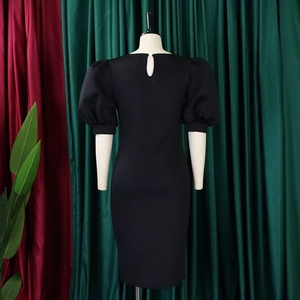 Detail of puff sleeves and back keyhole closure on a black slim fit dress