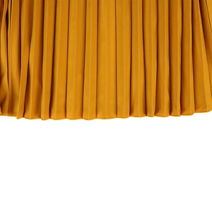 Detailed macro view of ginger yellow pleated fabric with professional hemmed edge stitching