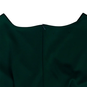 Macro view of the dark green V-neck dress featuring a seamless invisible back zipper detail