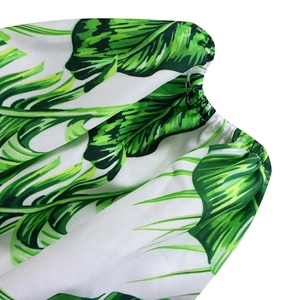 Détail du tissu à imprimé palmier tropical avec poignet élastique sur la manche du haut