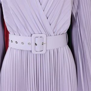 Détail d'une robe longue plissée lilas avec une large ceinture assortie et des œillets