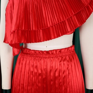 Detail of red pleated satin two-piece set featuring layered ruffles and elastic waist