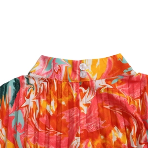 Detail of high collar with double buttons and marble print on pleated fabric