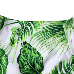 Détail de l'imprimé feuilles de palmier tropicales sur tissu blanc et coutures fines