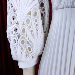 Detail of elegant white lantern sleeves with lace hollow patterns and pleated fabric texture