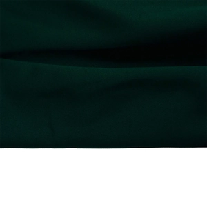 Detailed close-up showing the dark green textile fabric and texture of the evening dress