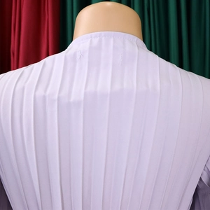 Détail de la robe plissée lilas montrant le col montant et la texture plissée verticale