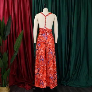 Detail of red paisley wide-leg jumpsuit showing back cross straps and flowing chiffon fabric