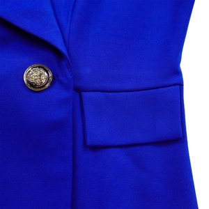 Vue détaillée du blazer bleu roi montrant le bouton doré à armoiries et la texture du tissu
