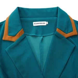 Detail des blaugrünen Blazer-Kragens mit orangefarbenem Kontrastrand und feiner Textur